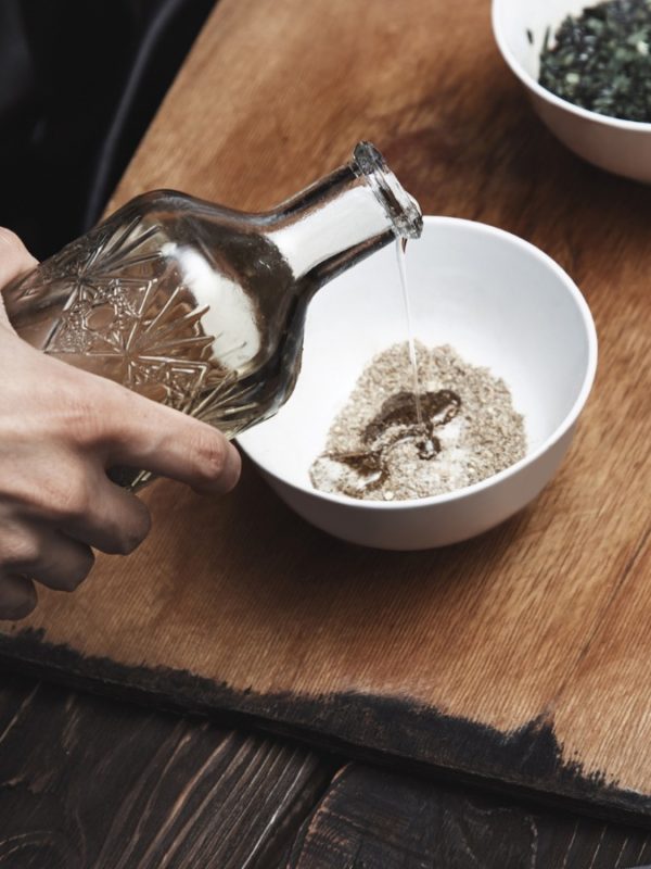 Fish marinade being pored into a bowl on a wooden cutting board awaiting fish soon to be prepped.