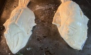 Two fish pies baking in an oven