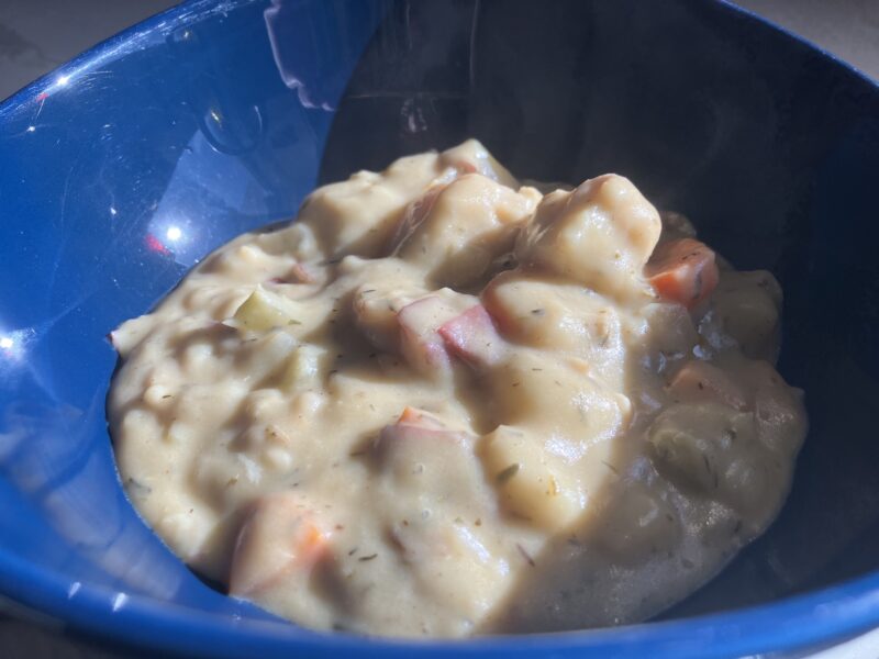 Creamy fish chowder in a blue bowl.